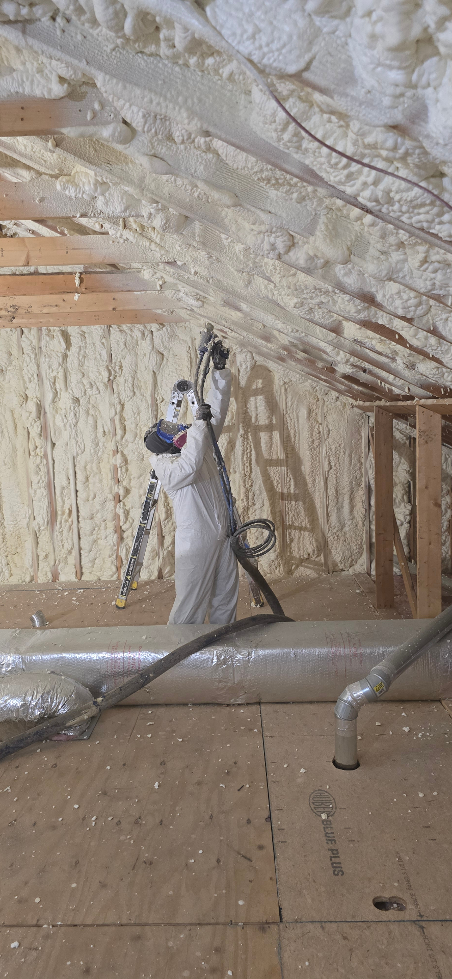 Professional installer applying spray foam insulation